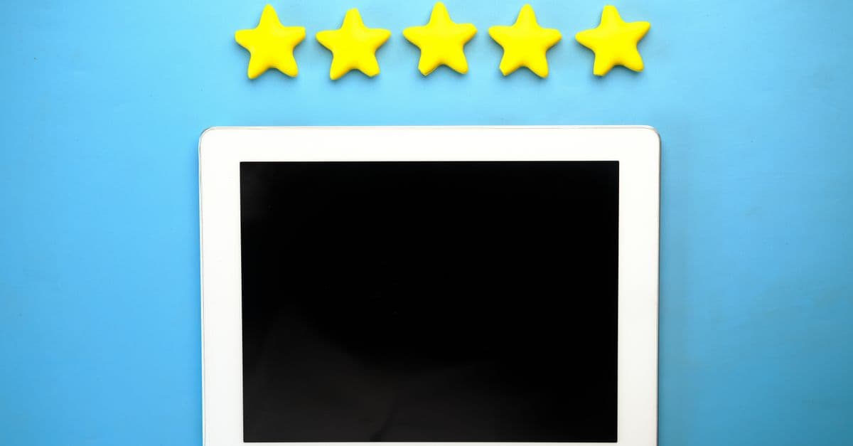 Tablet with five yellow stars on a blue background, ideal for rating concepts.