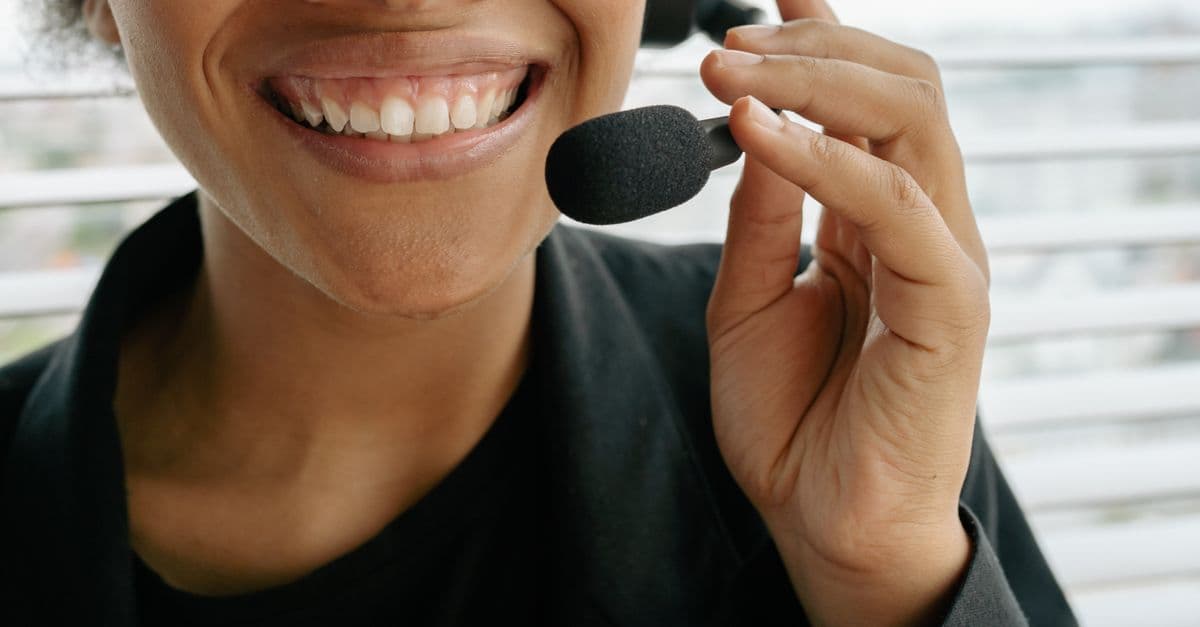 Close-up of a smiling call center representative holding a microphone.